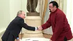  Presiden Rusia Vladimir Putin bersalaman dengan aktor AS Steven Seagal usai menandatangani paspor di Kremlin, Rusia, (25/11). Putin mengeluarkan keputusan memberi status kewarganegaraan bagi Steven Seagal. (Sputnik/Kremlin/Alexei Druzhinin via REUTERS)