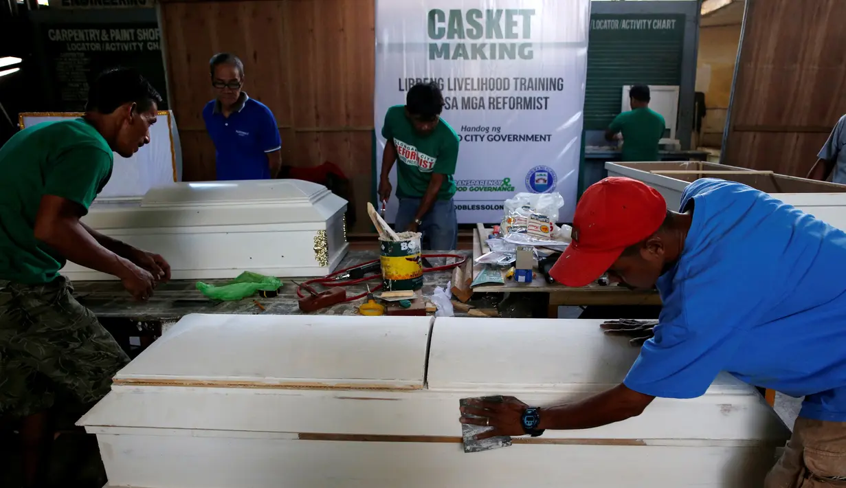 Mantan pengguna narkoba melakukan pembuatan peti mati di kota Olongapo, Filipina utara, (5/10). Langkah tegas Presiden Filipine Rodrigo Duterte membuat ribuan pengguna narkoba menyerahkan diri untuk menjalani rehabilitasi. (REUTERS/Erik De Castro)