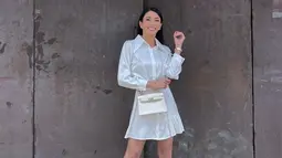 Busana berbahan satin juga menjadi salah satu pilihan OOTD Tyas Mirasih. Bintang film 'The Tarix Jabrix' ini tampil stunning dengan dress putih mini. Gayanya semakin kece dengan tas kecil dengan warna senada. Tak hanya itu, jam tangan yang dikenakannya juga senada. (Liputan6.com/IG/@tyasmirasih)