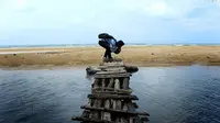 Salah seorang pengunjung mencicipi rasa air tawar yang berada persis di tepian Pantai Badur, Sumenep, Jawa Timur. (Foto: Pemkab Sumenep for Radar Bali/Jawa Pos Group)