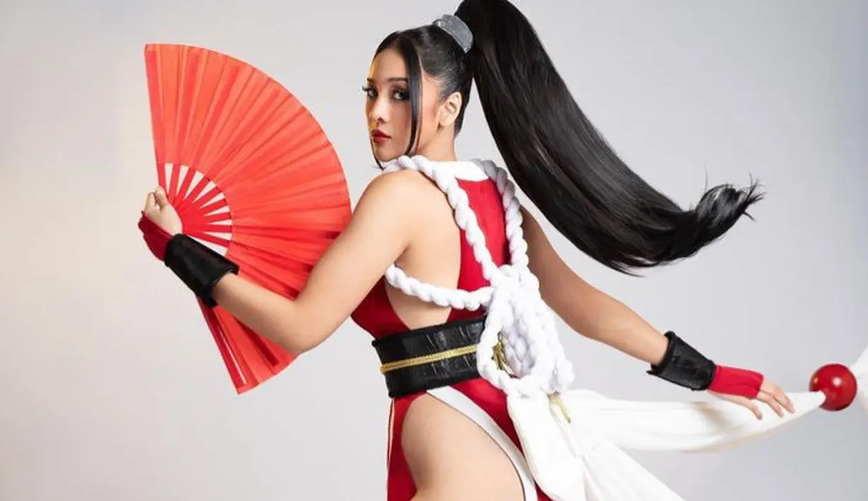 Di bagian belakang, Anya mengenakan aksen tali bersimpul putih dengan aksen tali pita berbola merah. Lengkap dengan aksen hitam di tangan serta membawa kipas. [@anyageraldine]