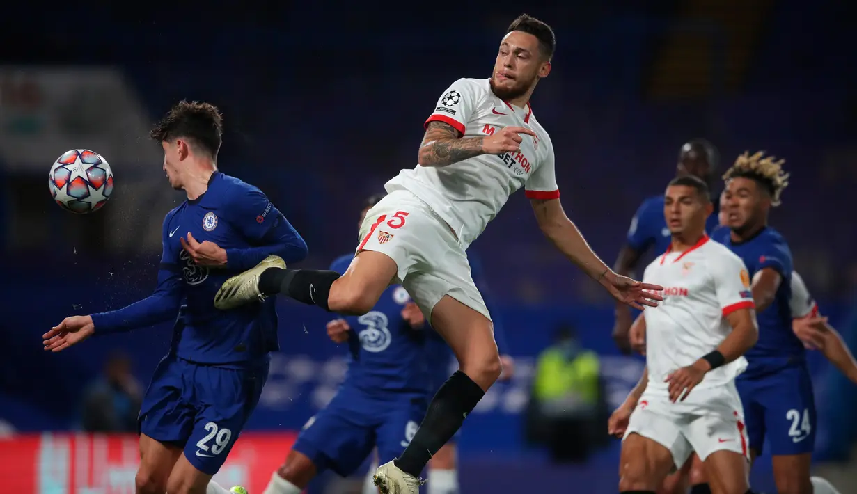 Gelandang Sevilla, Lucas Ocampos dan gelandang Chelsea, Kai Havertz berebut bola pada laga perdana Grup E Liga Champions 2020 di Stadion Stamford Bridge, Rabu (21/10/2020) dini hari WIB. Chelsea harus berbagi angka dengan tim tamu Sevilla setelah bermain imbang tanpa gol. (Adam Davy/PA, Pool via AP)