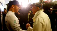 Lewis Hamilton dan Sir Jackie Stewart, sama-sama pengoleksi tiga gelar juara dunia F1 asal Inggris yang bertemu usai F1 GP AS di Sirkuit The Americas, Austin, AS, Senin (26/10/2015) dini hari WIB. (Reuters/Mike Stone)