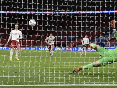 Pemain Denmark Christian Eriksen (kiri) mencetak gol ke gawang Inggris dari titik penalti pada pertandingan UEFA Nations League di Stadion Wembley, London, Inggris, Rabu (14/10/2020). Denmark menang 1-0. (Daniel Leal-Olivas/Pool via AP)
