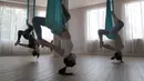Para murid melakukan gerakan aerial yoga atau yoga udara di Aerial Jooga Studia, Kelapa Dua, Tangerang, Banten, Minggu (10/10/2021). Di masa pandemi, peminat olahraga yang berasal dari Amerika Serikat ini meningkat lebih dari 60 persen. (merdeka.com/Arie Basuki)