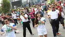 Peserta mengikuti kegiatan body combat dalam acara sosialisasi bertajuk karnaval pekerja di area Car Free Day (CFD) Jalan Jenderal Sudirman, Jakarta Pusat, Minggu (14/5). (Liputan6.com/Immanuel Antonius)