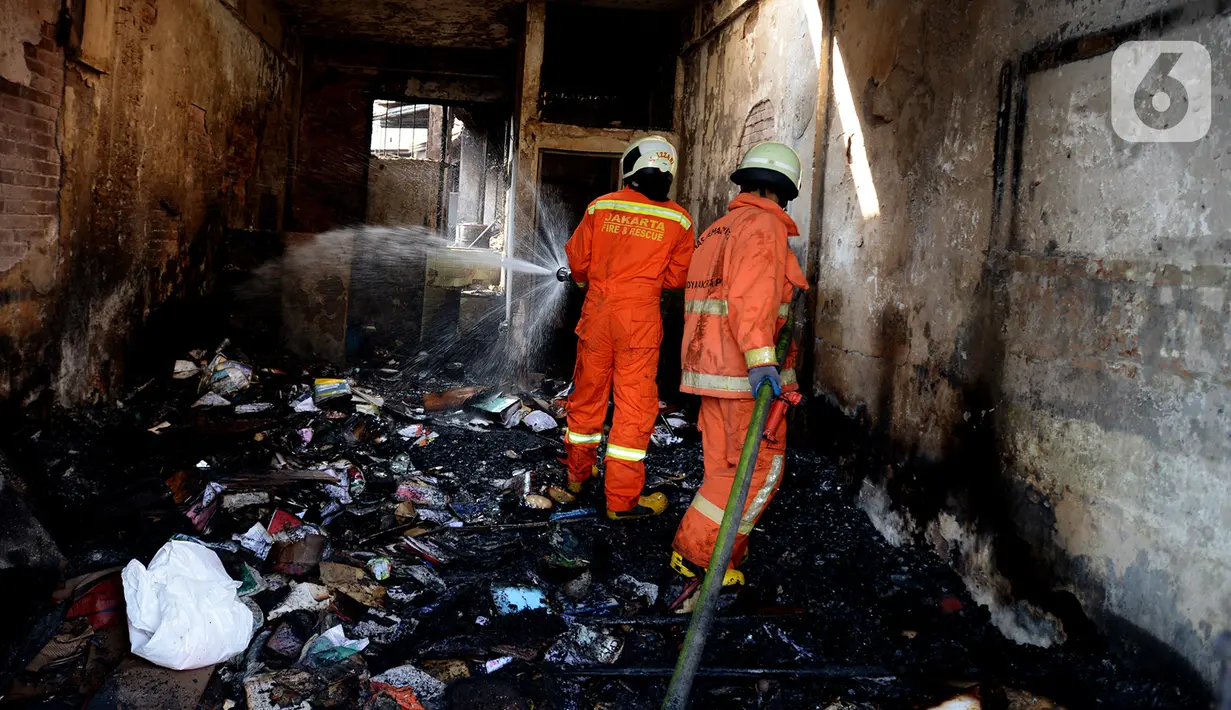 Petugas pemadam kebakaran melakukan pembasahan bioskop Grand Theater yang terbakar di Simpang Lima Senen, Jakarta, Jumat (9/10/2020). Unjuk rasa menentang disahkannya Omnibus Law UU Cipta Kerja berujung aksi anarkis merusak berbagai fasilitas umum pada Kamis malam (8/10). (merdeka.com/Imam Buhori)