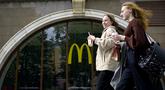 Perempuan berjalan melewati restoran McDonald's yang tutup di Moskow, Rusia pada 16 Mei 2022. Raksasa makanan cepat saji asal Amerika, McDonald's, akan keluar dari pasar Rusia dan menjual bisnisnya di negara yang semakin terisolasi itu, kata perusahaan tersebut pada Senin kemarin. (Natalia KOLESNIKOVA / AFP)