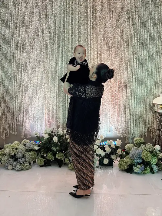 Sementara Baby Kyarra tampak girang dan menggemaskan kenakan dress hitam dan sepatu silver [@jscmila]