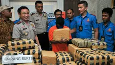 Tersangka MS (tengah) menunjukkan ganja miliknya seberat 219 kg, Jakarta, Kamis (3/12/2015). Tersangka MS dijerat pasal berlapis dengan ancaman hukuman mati. . (Liputan6.com/Yoppy Renato)