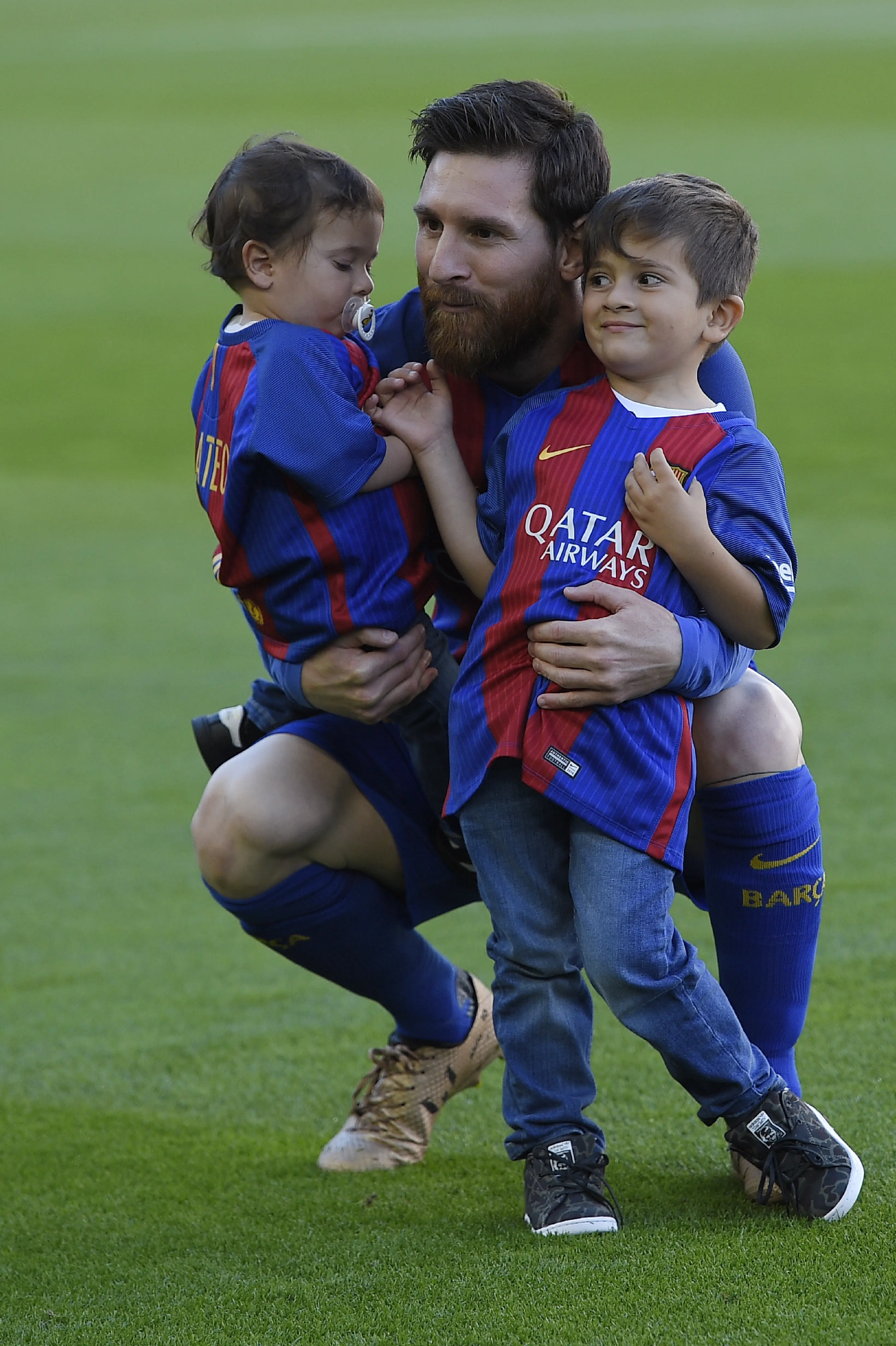 Lionel Messi bersama kedua putranya, Mateo dan Thiago. (AFP/Lluis Gene)