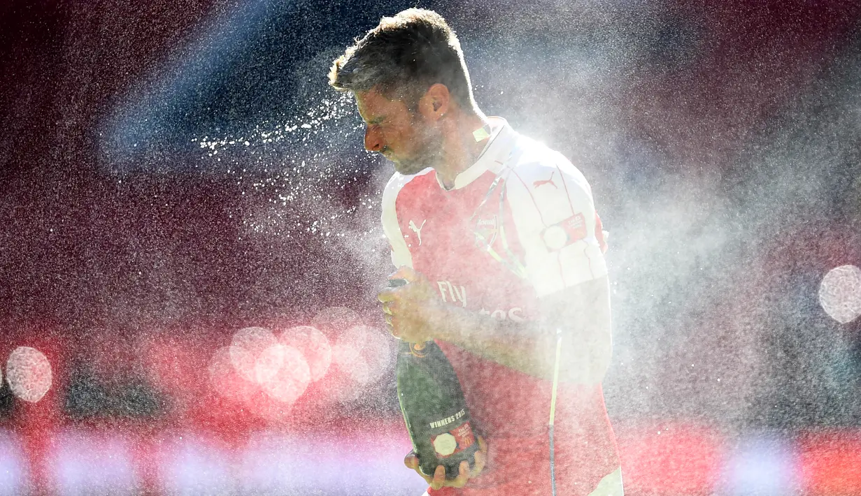 Penyerang Arsenal, Olivier Giroud menyemprotkan sampanye saat merayakan kemenangan di Community Shield di Wembley Stadium, Minggu (2/8/2015). Arsenal menang atas Chelsea dengan skor 1-0. (Reuters/Dylan Martinez)