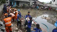 Petugas Suku Dinas Sumber Daya Air dan PPSU mengganjal tanggul yang jebol dengan karung pasir di kawasan Jatipadang, Jakarta, Selasa (12/12). Untuk kesekian kalinya dalam waktu berdekatan, tanggul darurat Kali Pulo jebol. (Liputan6.com/Immanuel Antonius)