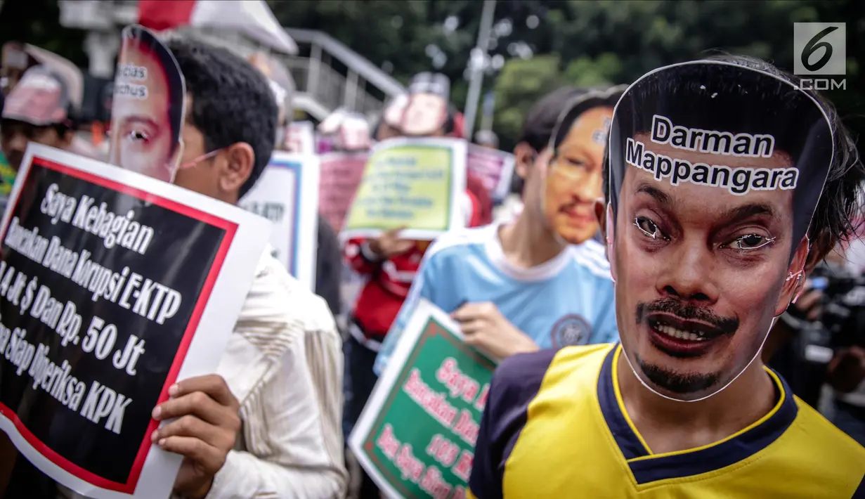 Peserta aksi mengenakan topeng sejumlah tokoh yang diduga terlibat kasus e-KTP saat menggelar unjuk rasa di depan Gedung KPK, Jakarta, Rabu (29/11). Mereka meminta KPK untuk mengusut kasus e-KTP lebih dalam lagi. (Liputan6.com/Faizal Fanani)