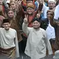 Pasangan capres dan cawapres Prabowo Subianto-Sandiaga Uno menaiki bersama pendukungnya menunjukkan salam dua jari saat mengikuti pawai Deklarasi Kampanye Damai di Monas, Minggu (23/9). (Merdeka.com/Iqbal Nugroho)