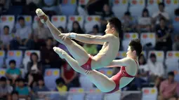 Aksi atlet loncat indah China, Lian Junjie dan Si Yajie saat tampil pada babak final platform sinkronisasi 10 meter campuran di Kejuaraan Renang Dunia, Gwangju, Korea Selatan, Sabtu (13/7/2019). (AP Photo/Lee Jin-man)