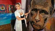 Seniman asal Ukraina, Dariya Marchenko memperlihatkan lukisan wajah Presiden Rusia, Vladimir Putin yang dibuatnya di Kiev, Ukraina (27/7/2015). 5.000 peluru dihabiskan Dariya yang diambil dari lokasi peperangan di Ukraina Timur. (REUTERS/Gleb Garanich)