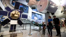 Pengunjung melihat model modul inti stasiun ruang angkasa Mir di Memorial Museum of Cosmonautics di Moskow (20/8/2019).  Museum ini didedikasikan untuk eksplorasi ruang angkasa khususnya yang berkaitan dengan ruang angkasa Soviet dan Rusia. (AFP Photo/Kirill Kudryavtsev)