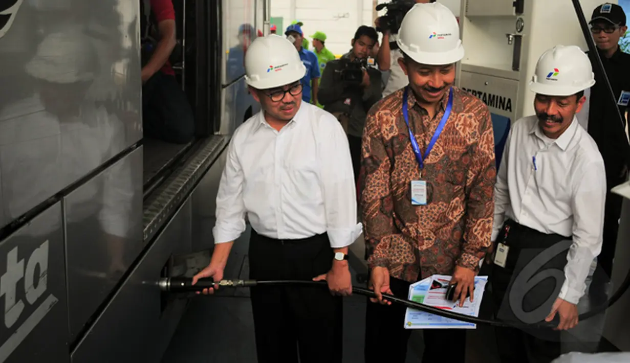 Menteri ESDM Sudirman Said (kiri) sempat menjadi petugas SPBG dadakan yang melayani pengisian Bahan Bakar Gas (BBG) bus TransJakarta, Lebak Bulus, Jakarta, Selasa (3/3/2015). (Liputan6.com/Yoppy Renato)