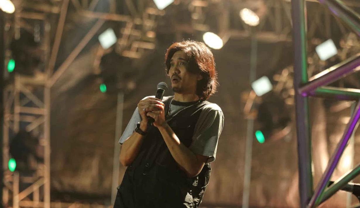 Duta, sang vokalis, tampil sangat komunikatif dan enerjik menyapa para penggemarnya yang disebut Sheila Gank. Tampak dalam foto, Vokais grup band legendaris asal Yogyakarta, Sheila On 7, Duta saat tampil pada hari kedua gelaran KapanLagi Buka Bareng (KLBB) Festival 2026 di Stadion Madya, Kompleks Gelora Bung Karno, Senayan, Jakarta, Minggu 1 Maret 2026. (Fimela.com/Adrian Putra)