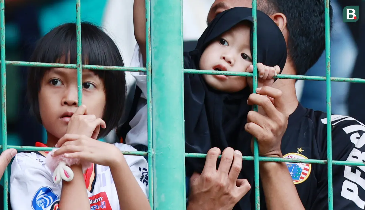 Suporter Cilik saat menyaksikan pertandingan Persija Jakarta melawan Arema FC pada laga BRI Liga 1 di Stadion Patriot Candrabhaga, Bekasi, Minggu (12/2/2023). Sejumlah fans balita tampak menghiasi tribun penonton. (Bola.com/M Iqbal Ichsan)