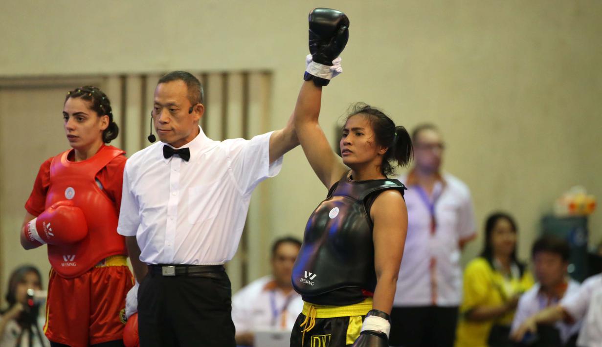 Atlet wushu Indonesia, Moria Manalu (kanan), menang atas lawannya asal Turki, Nagihan Kalyoncu di kelas Sanda Wanita 60 kg pada Kejuaraan Dunia Wushu 2015 di Istora Gelora Bung Karno, Senayan, Jakarta, Senin (16/11/2015). (Bola.com/Nicklas Hanoatubun)