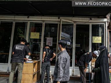 Warga menerima kopi gratis di Filosofi Kopi Melawai, Jakarta, Rabu (30/6/2021). Filosofi Kopi memberikan kopi gratis bagi warga yang telah melakukan vaksinasi COVID-19. Kegiatan tersebut merupakan bentuk dukungan kepada masyarakat agar melakukan vaksinasi COVID-19. (Liputan6.com/Faizal Fanani)