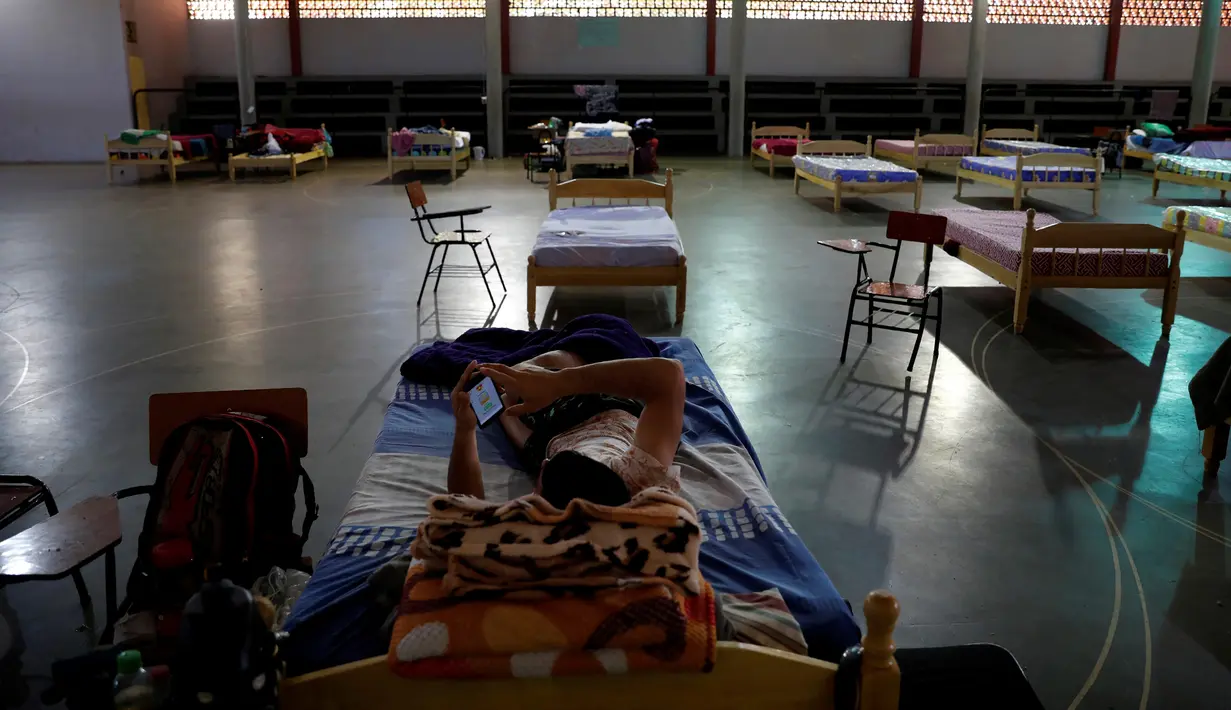 Seorang pemuda yang menjalani karantina beristirahat di sebuah sekolah di Ciudad del Este, Paraguay, Kamis (24/6/2020). Pemuda itu mengatakan dia dikarantina selama 70 hari sebelum dia pergi. (AP Photo/Jorge Saenz)