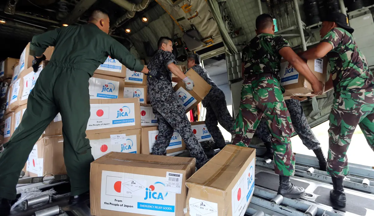 Personil militer Jepang dibantu TNI mengangkut bantuan logistik dari pesawat kargo AU Jepang di bandara Mutiara Sis Al-Jufri, Palu, Sulteng (6/10). Gempa berkekuatan 7,5 mengguncang kota Palu pada 28 September. (AP Photo/Tatan Syuflana)