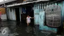 Soerang anak berdiri di dekat rumahnya yang tergenang banjir di Kawasan Muara Angke, Jakarta, Rabu (11/1). Banjir ini juga telah merendam ratusan rumah, toko, dan tempat pengeringan ikan asin. (Liputan6.com/Gempur M. Surya)
