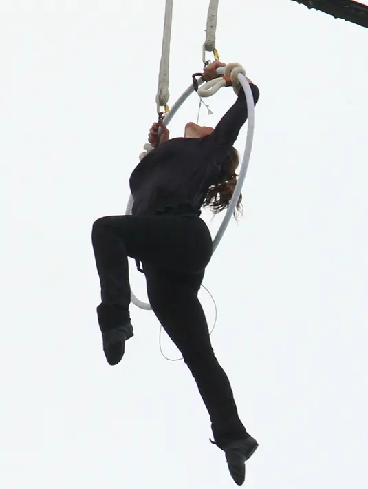 Seorang akrobatis udara asal Amerika, Erendira Wallenda bergelantungan pada sebuah helikopter menggunakan giginya, Kamis (15/7). Aksi bergelantungan di atas air terjun Niagara dengan giginya itu berhasil memecahkan rekor dunia. (AP Photo/Bill Wippert)