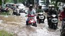 Sejumlah  pengendara sepeda motor menerobos sebagian Jalan Bungur Besar Raya yang tergenang air, Jakarta, Selasa (18/1/2022). Genangan air membuat arus lalu lintas di sekitar depan PN Jakarta Pusat menjadi terganggu dan tersendat. (Liputan6.com/Helmi Fithriansyah)