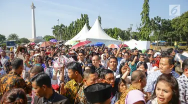 Warga mengantre di kawasan Silang Monas, untuk mengikuti Open House Jokowi di Istana Kepresidenan, Jakarta Rabu (5/6/2019). Warga mulai rela antre setelah Salat Id meski Istana baru dibuka pada pukul 10.00 WIB. (Liputan6.com/HO/Grandy)