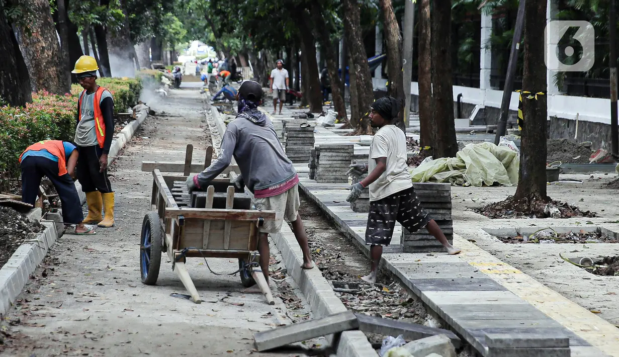 Pekerja menyelesaikan proyek revitalisasi pedestrian di kawasan Jalan Pattimura, Jakarta, Rabu (8/6/2022). Dinas Bina Marga DKI Jakarta merevitalisasi pedestrian dengan memperlebar menjadi tiga meter sehingga cukup luas untuk memberikan kenyamanan para pejalan kaki. (Liputan6.com/Faizal Fanani)