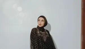 Tampil elegan di momen Idul Fitri dengan kaftan nuansa hitam dan emas seperti yang dikenakan Zaskia Sungkar ini. Untuk hijab, kamu bisa kenakan warna senada dengan model ikat. (Instagram/zaskiasungkar15).