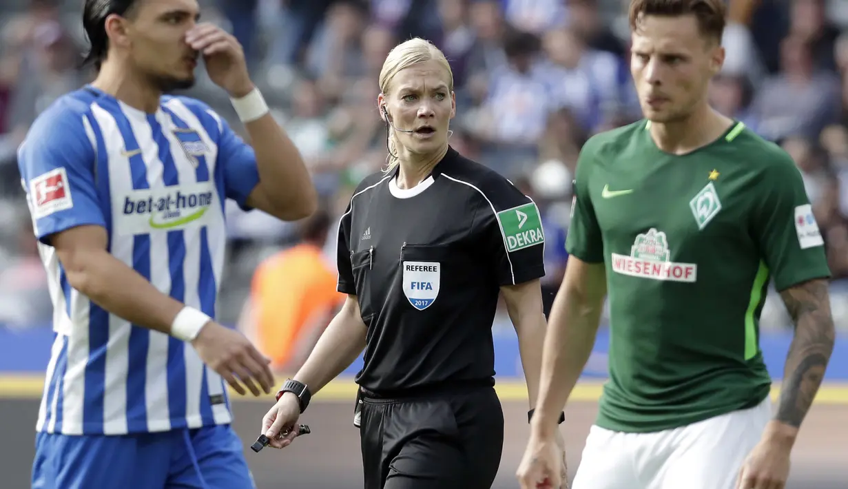 Ekspresi wasit wanita, Bibiana Steinhaus saat memimpin laga  Hertha Berlin dan Werder Bremen  pada lanjutan Bundesliga di Berlin, Jerman (10/9/2017). Laga tersebut merupakan debut Bibiana Steinhaus.  (AP/Michael Sohn)