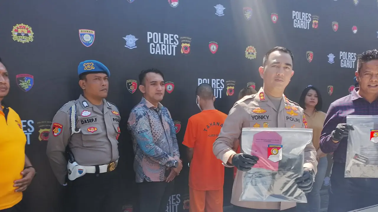 Kapolres Garut, AKBP Rohman Yonky Dilatha didampingi Kasatreskrim Garut AKP Ari Rinaldo menunjukan barang bukti milik pelaku adegan live mesum beberapa waktu lalu. (Liputan6.com/Jayadi Supriadin)