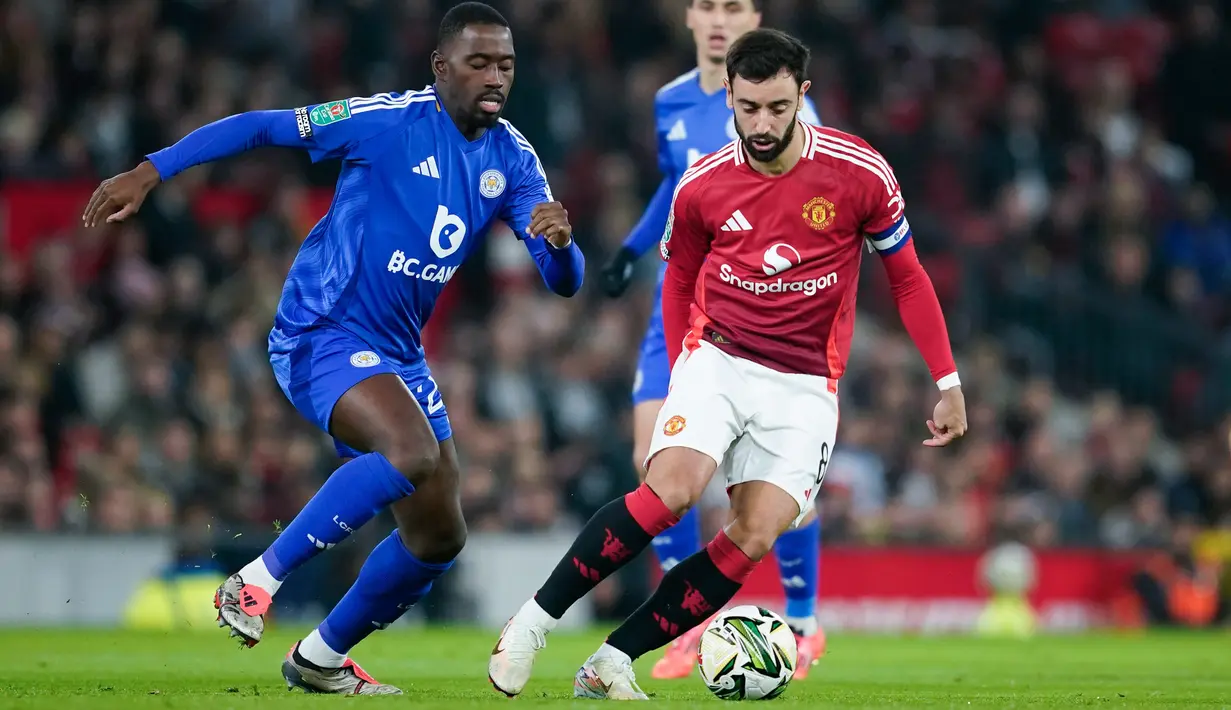 Pemain Manchester United, Bruno Fernandes berusaha melewati pemain Leicester City, Boubakary Soumare, pada pertandingan babak 16 besar Carabao Cup di Stadion Old Trafford, Kamis (31/10/2024). (AP Photo/Dave Thompson)