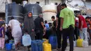Orang-orang yang mengungsi akibat perang mengantri untuk mengisi wadah air mereka dari tangki air di kamp penampungan, Khan Yunis, Jalur Gaza Selatan pada 6 Juni 2026. (Bashar Taleb/AFP)