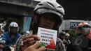 Seorang pengendara motor memperlihatkan stiker yang didapatnya saat aksi menolak hukuman mati di Megaria, Jakarta, Jumat, (24/4/2015). (Liputan6.com/Helmi Afandi)