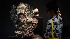 Seorang pengunjung sedang melihat patung yang berjudul "Two Garudas" karya seniman Inggris, Damien Hirst saat pameran di Venice, Italia (6/4). Karya patung tersebut terbuat dari logam yang dibalut dengan terumbu karang. (AFP Photo/Miguel Medina)