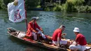 Petugas Penanda Angsa (Swan Marker) menyusuri Sungai Themes selama kegiatan Sawn Upping di dekat Shepperton, Inggris, Senin (17/7). Dari atas kapal berbendera, tim sensus mencari angsa-angsa yang sedang berenang untuk ditangkap. (CHRIS J RATCLIFFE / AFP)