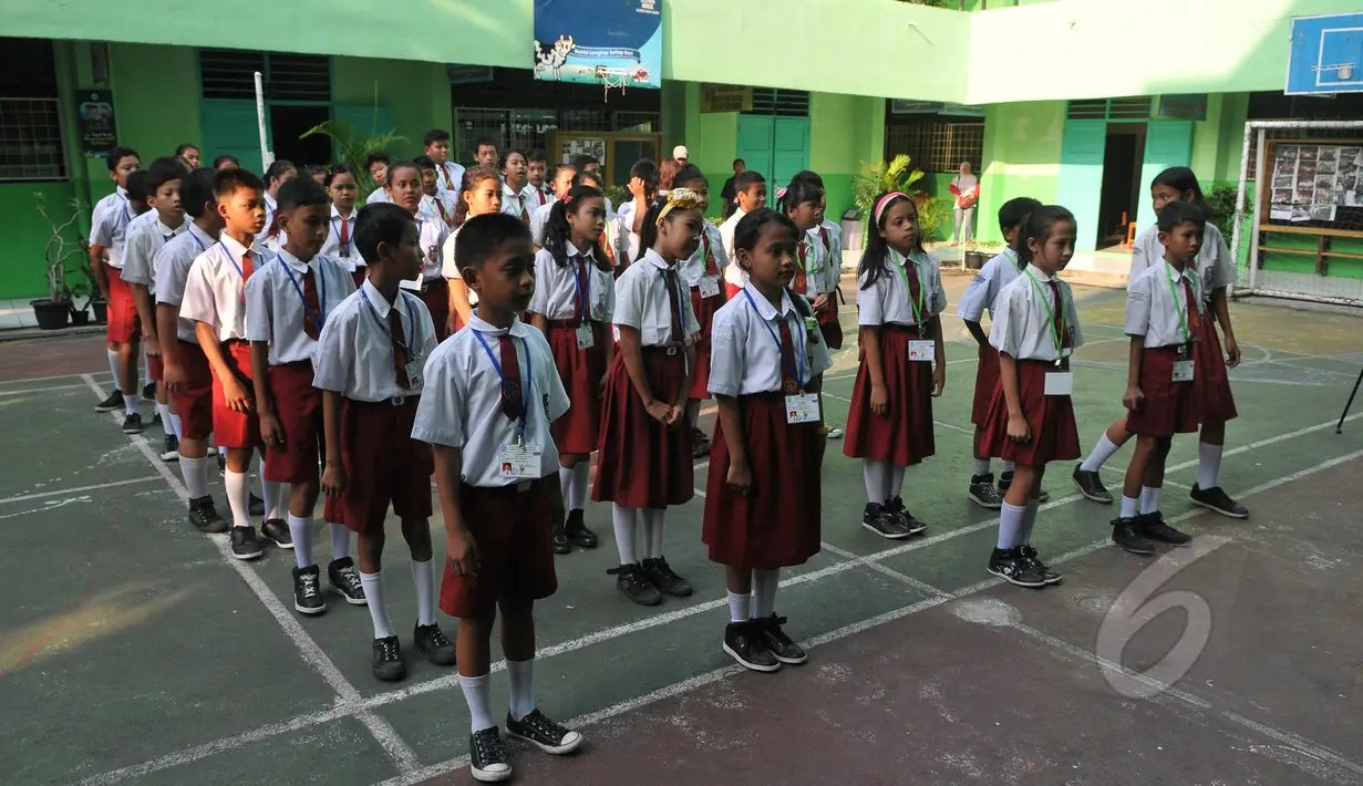 Sejumlah peserta mengikuti upacara pengarahan sebelum memulai Ujian Nasional (UN) di SDN 04 Jakarta, Senin (18/5/2015). Sebanyak 153.266 peserta didik SD/MI dan sederajat di Jakarta mengikuti UN yang digelar 18-20 Mei. (Liputan6.com/Herman Zakharia)