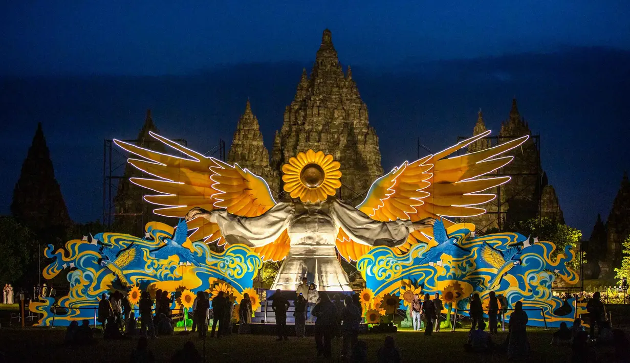 Orang-orang berkumpul di depan "Sunflower Angel", instalasi seni fiberglass setinggi sembilan meter karya seniman lokal Arrofi Ramadhan, di Candi Prambanan, kompleks candi Hindu abad ke-9 yang terdaftar sebagai Situs Warisan Dunia UNESCO, Sleman, Yogyakarta, pada Sabtu 6 Juni 2026. (DEVI RAHMAN/AFP)