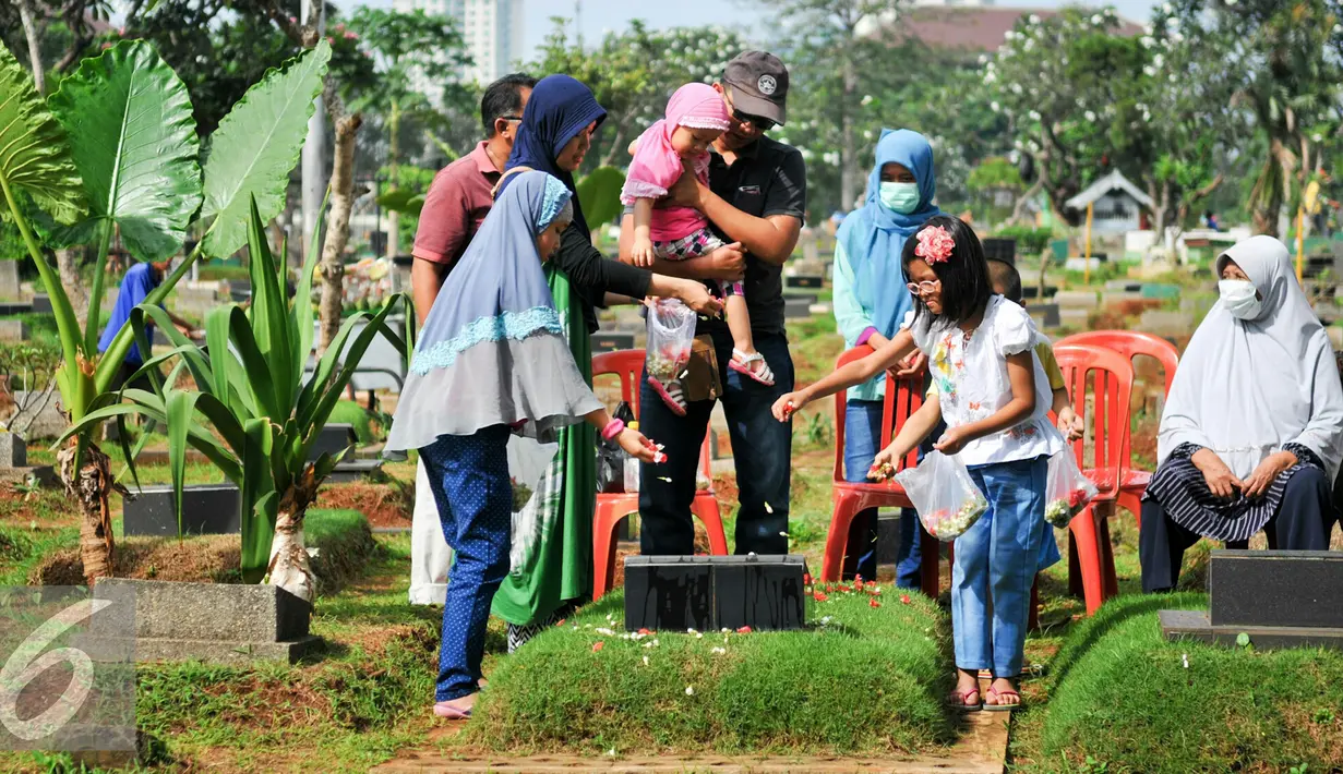 Warga menaburkan bunga di atas makam saat tradisi ziarah kubur di TPU Karet Bivak, Jakarta, Minggu (29/5/2016). Jelang bulan Ramadan, umat Muslim mulai ramai berziarah ke makam keluarganya. (Liputan6.com/Yoppy Renato)