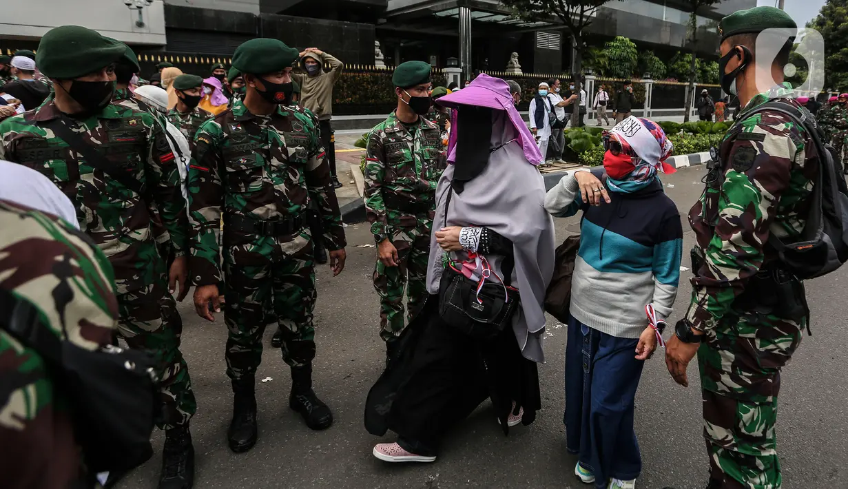 Aksi prajurit TNI menghalau massa yang hendak menggelar demonstrasi 1812 di sekitar Istana Negara, Jakarta, Jumat (18/12/2020). Aparat yang bertugas mencoba memberi tahu massa Aksi 1812 mengingat Jakarta masih dalam situasi pandemi Covid-19. (Liputan6.com/Johan Tallo)