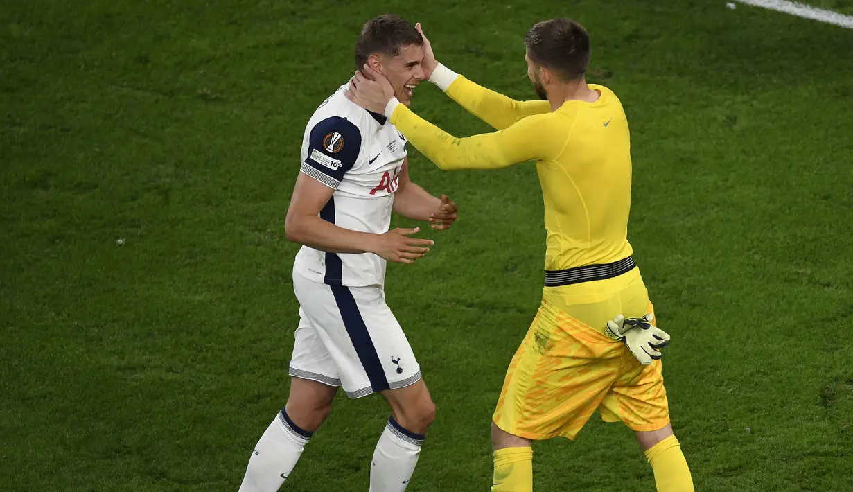Pemain Tottenham Hotspur, Micky van de Ven merayakan kemenangan bersama kiper Guglielmo Vicario setelah laga final Liga Europa 2024/2025 melawan Manchester United di Stadion San Mames, Bilbao, Spanyol, Kamis (22/05/2025) dini hari WIB. (AFP/Ander Gillenea)