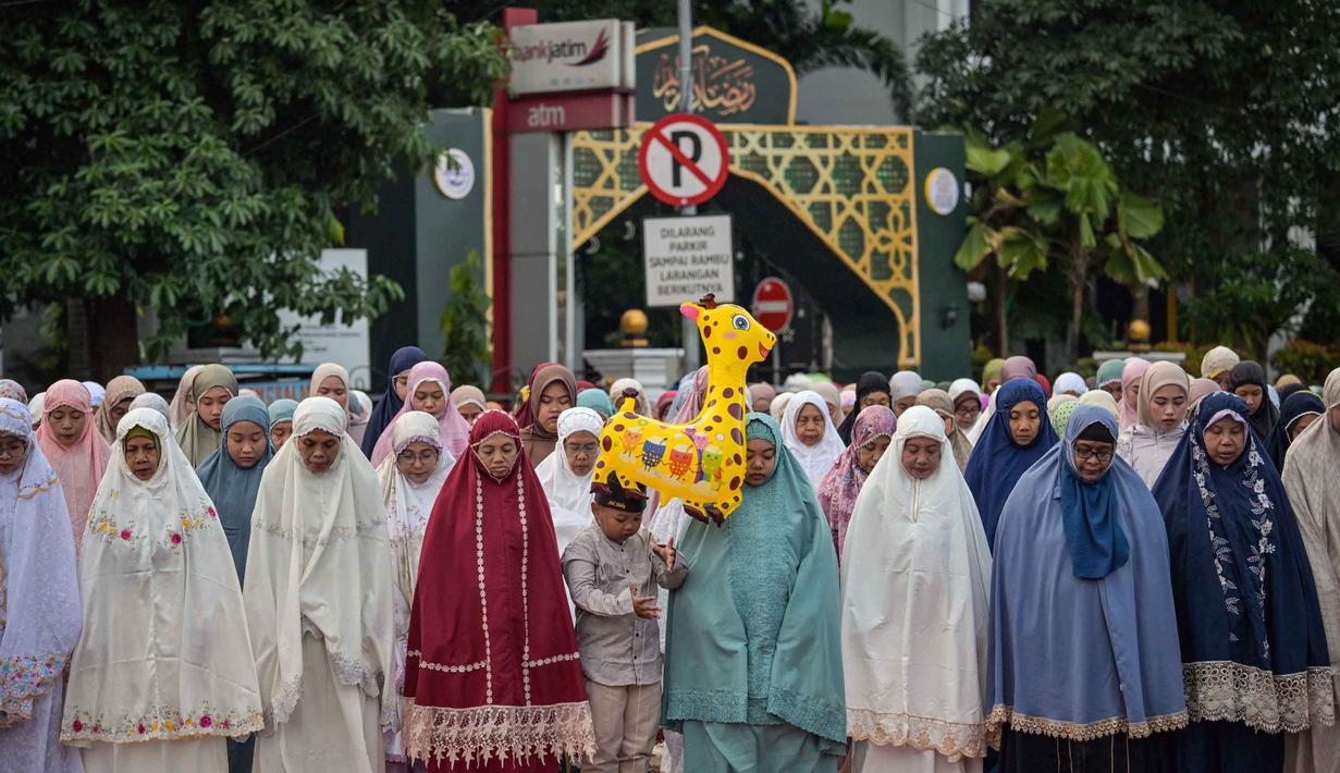 Sebagai informasi, penetapan 1 Syawal 1447 Hijriah atau Lebaran 2026 umat muslim Muhammadiyah berbeda dengan yang ditetapkan pemerintah. Tampak dalam foto, umat muslim saat melaksanakan salat Idul Fitri 1447 Hijriah di salah satu ruas jalan di kota Surabaya, Jawa Timur, pada Jumat 20 Maret 2026. (JUNI KRISWANTO/AFP)