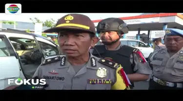 Puluhan personel kepolisian bersenjata lengkap disiagakan di pintu masuk penyebrangan pelabuhan laut Ketapang, Banyuwangi.