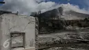 Gunung Sinabung terlihat dari puing rumah yang rusak akibat luncuran awan panas pada April 2015 di Desa Sibintun, Karo, Sumatera Utara, Minggu (5/7/2015). Akibat letusan Sinabung, desa tersebut sudah tak lagi berbentuk. (Liputan6.com/Johan Tallo)